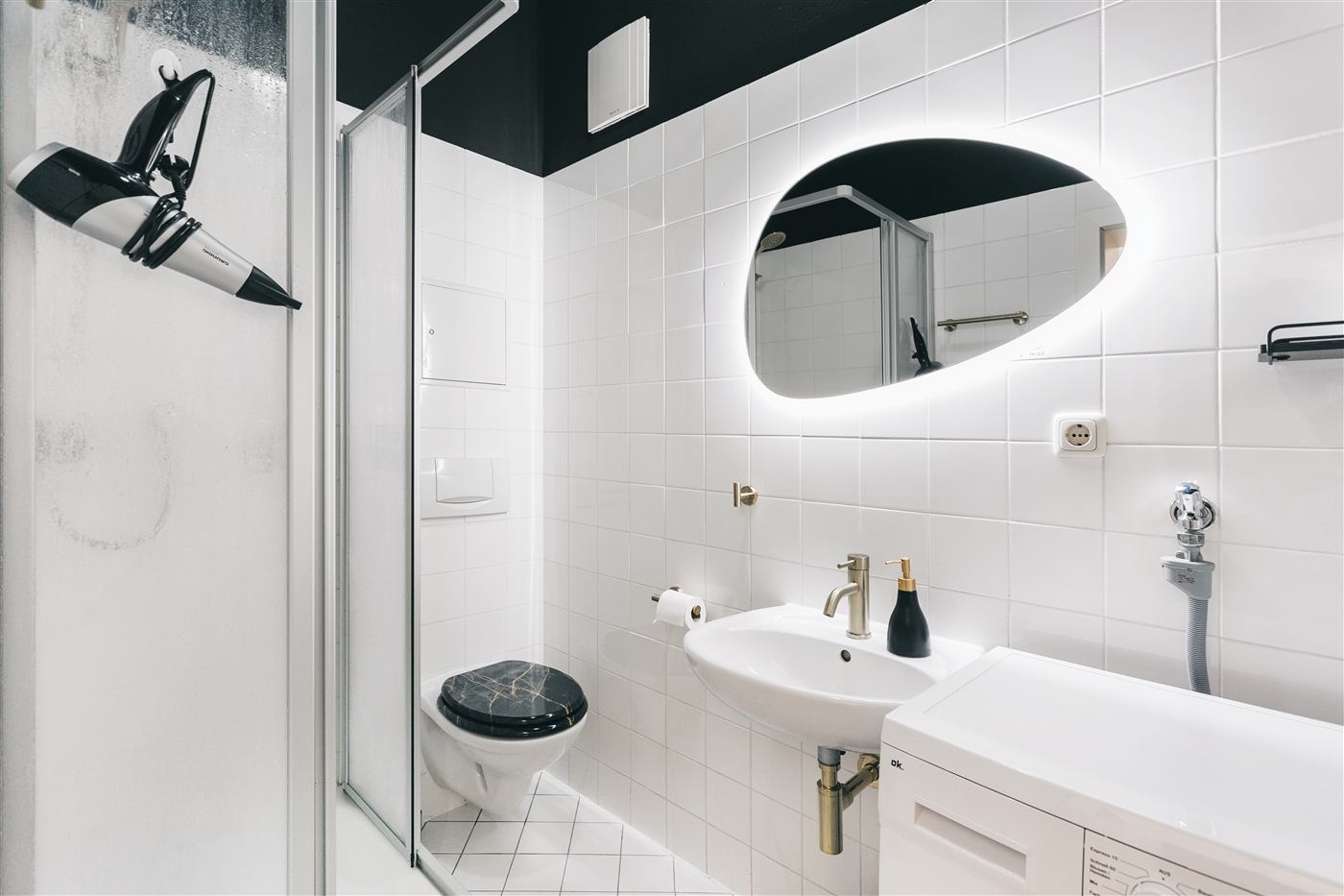 Bad mit Dusche, Waschmaschine und Spiegel im Junior Apartment Meißen